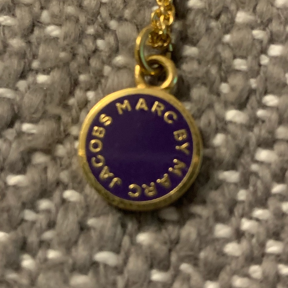 Small purple pendant necklace with gold chain.